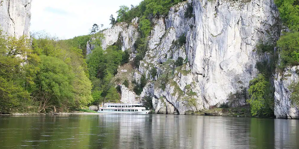 Foto eines Personenschiffes, das durch die imposante Felsformation Donaudurchbruch fährt